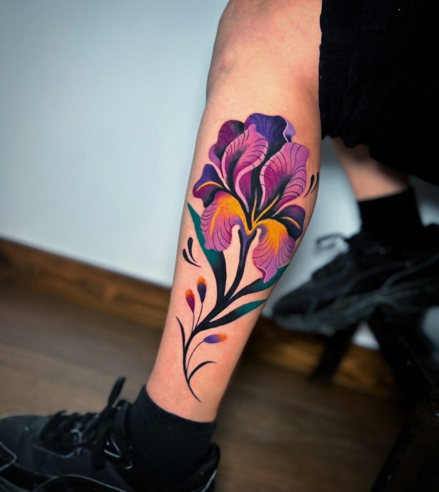 This stunning tattoo features a flower design in bold purples and yellows, creating an eye-catching aesthetic.
