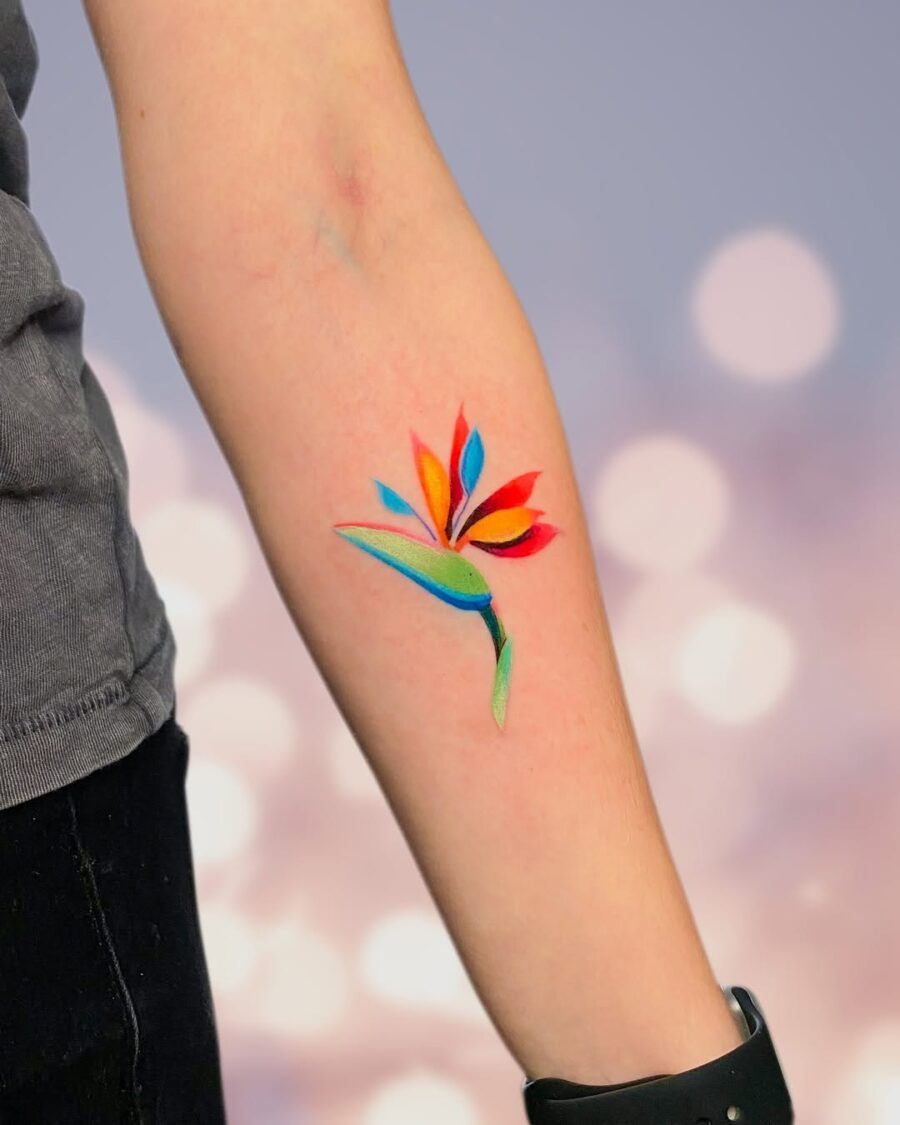 This tattoo showcases a stunning, colorful flower blooming against the skin.
