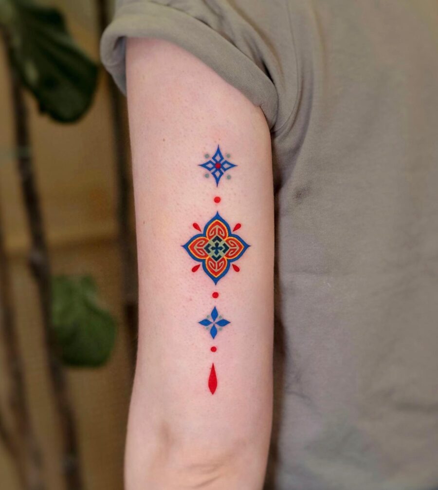 This tattoo stands out with its bold colors and intricate geometric patterns.