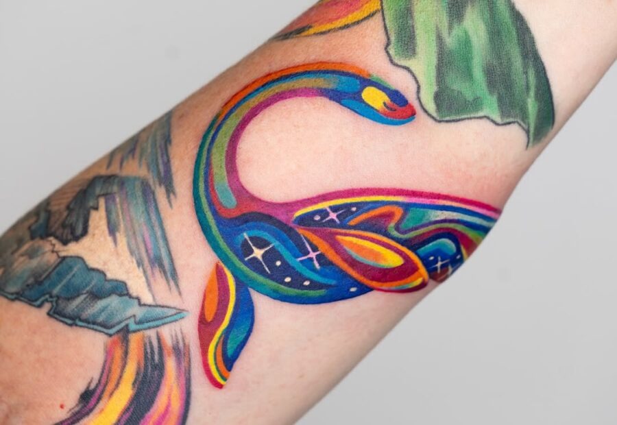 This tattoo features a snake elegantly coiling with radiant colors.