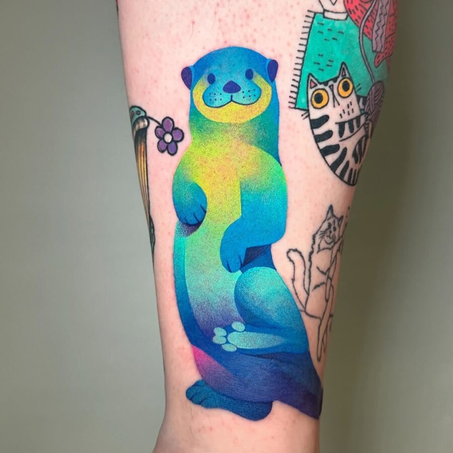 This bright otter tattoo showcases a playful design in striking blue and green hues.