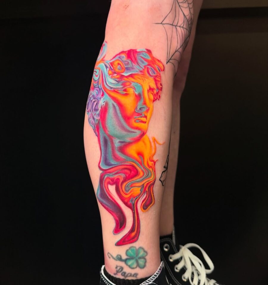 This tattoo combines vivid colors with classical elements, showing an artistic rendition of a well-known figure.