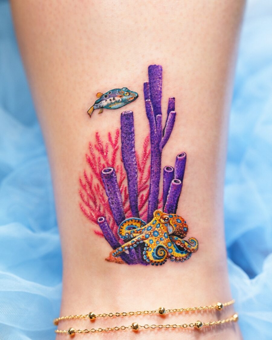 This colorful tattoo showcases a lively underwater scene with a beautifully designed octopus, coral, and a fish.