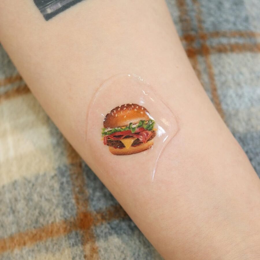 Vibrant hamburger tattoo with playful elements Tattoo Design