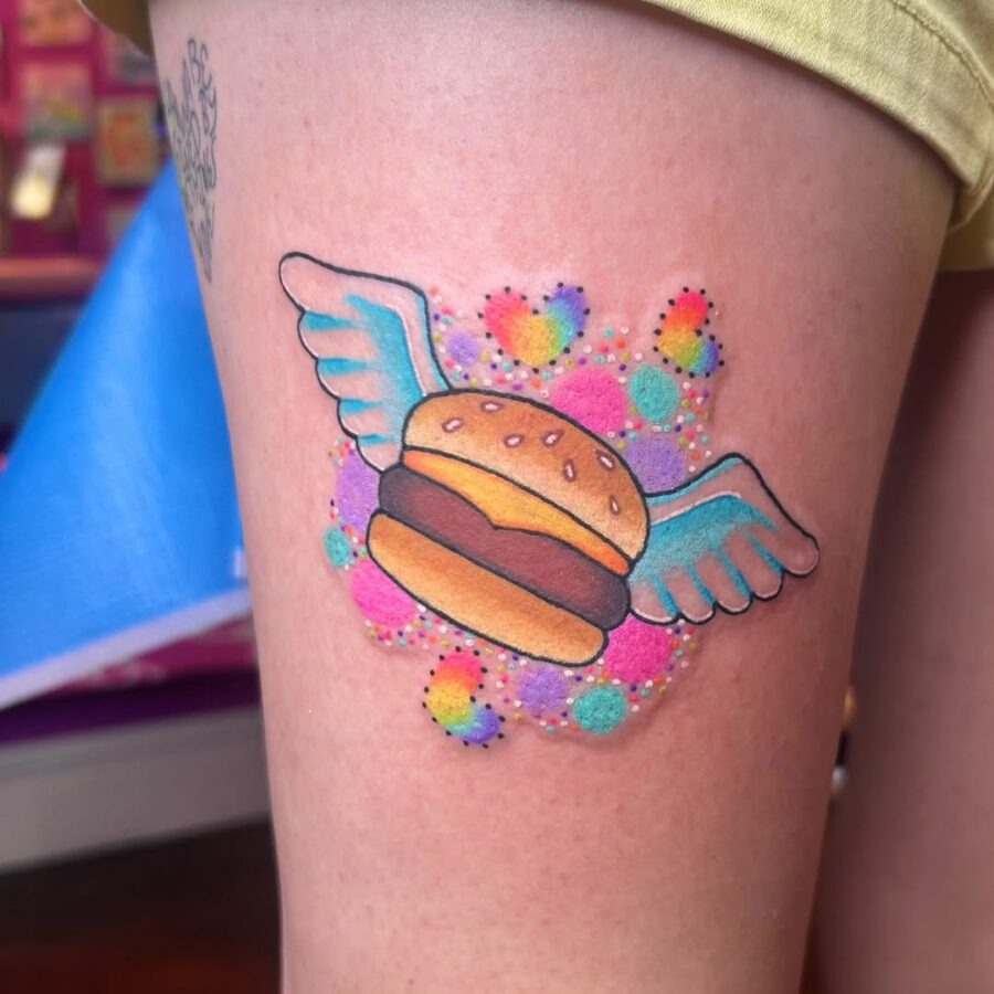 Whimsical burger tattoo with cute wing details Tattoo Design
