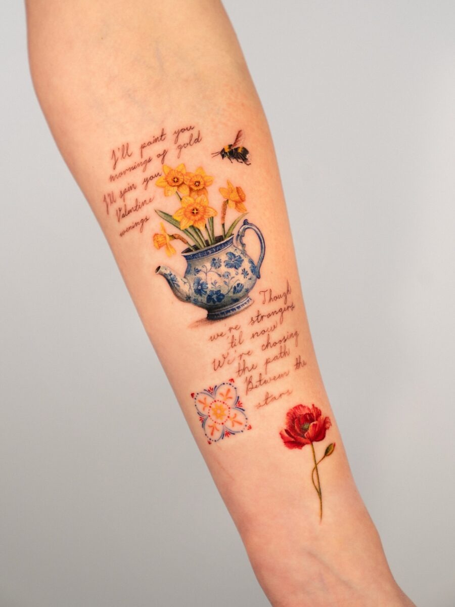 This tattoo features a buttercup along with other cheerful flowers in a teapot.
