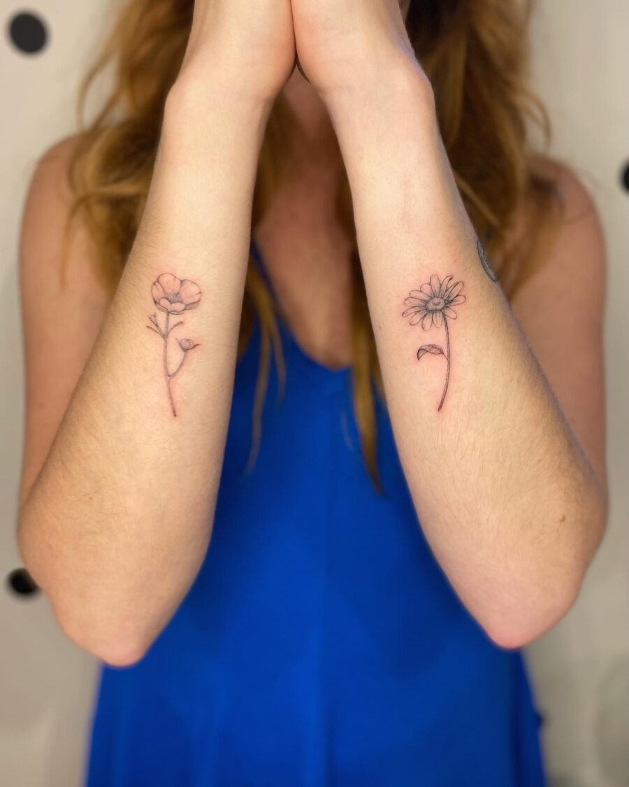 This image features delicate buttercup flower tattoos on both forearms, symbolizing beauty and simplicity.
