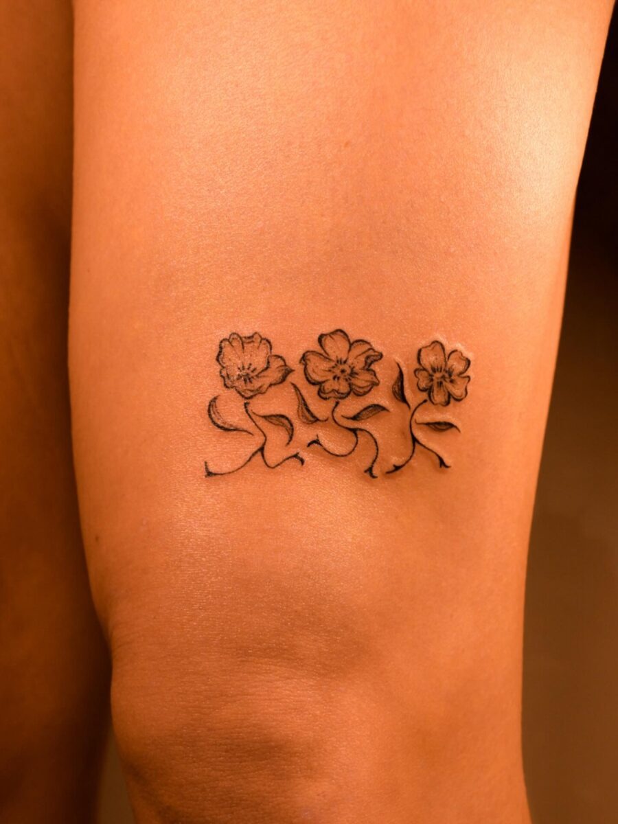 This tattoo features delicate buttercup flowers elegantly inked.
