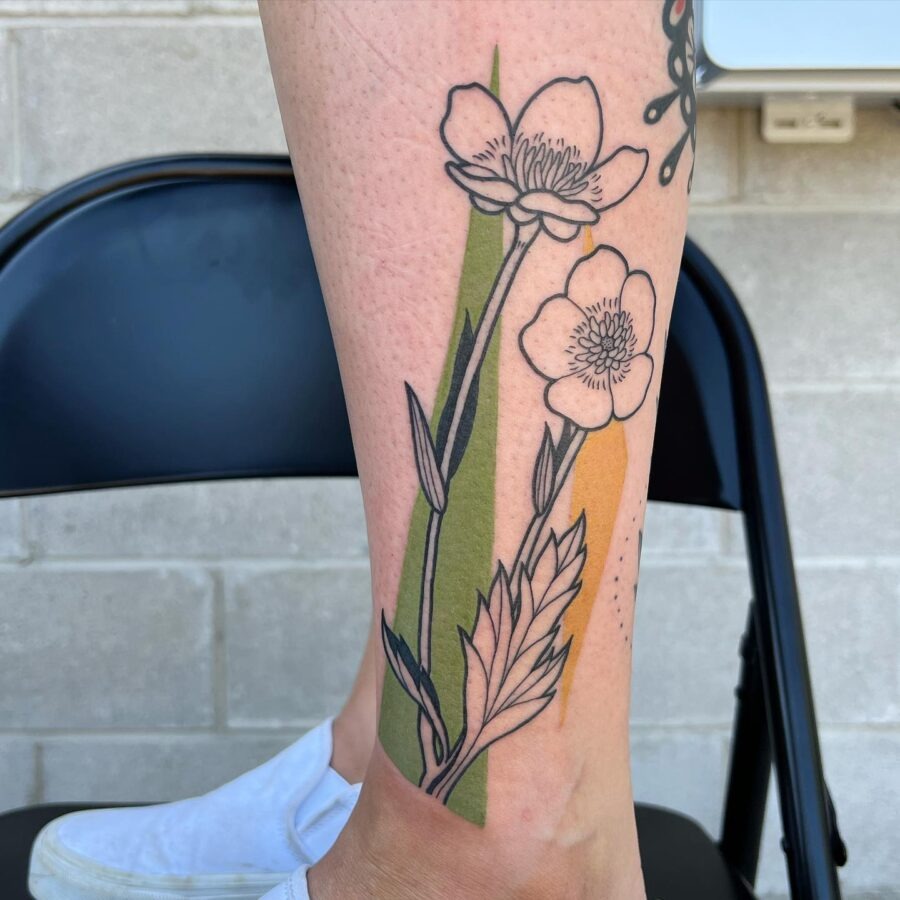 This tattoo features elegant buttercup flowers with delicate outlines, set against a stylish backdrop of green and yellow.