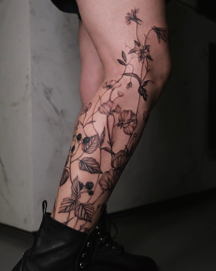 This tattoo features an intricate design of buttercups entwined with delicate leaves and other florals.