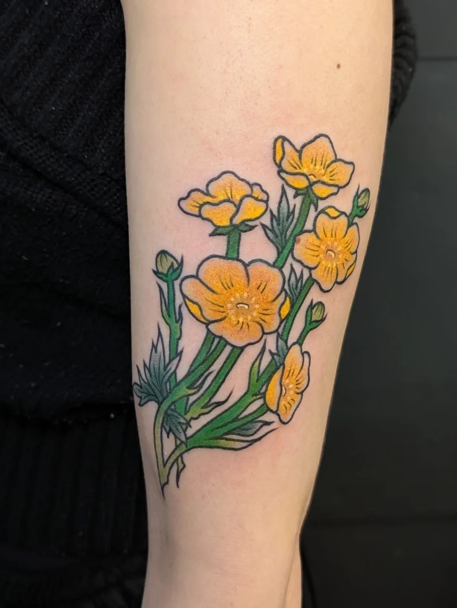 This tattoo showcases stunning yellow buttercups with intricate detailing.