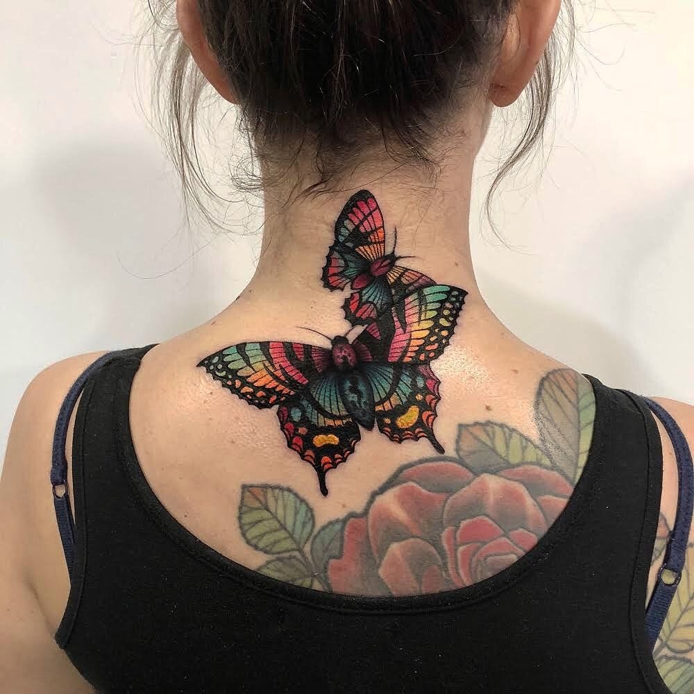 Vibrant Butterfly with Bold Colors on the Neck and Upper Back Tattoo Design