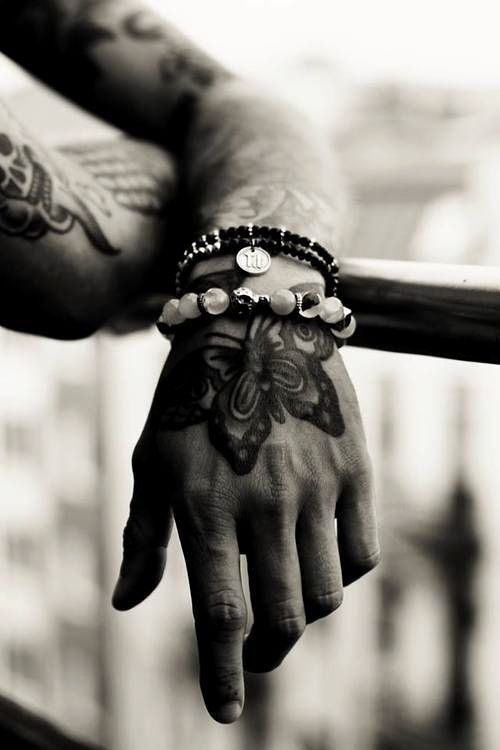 Attractive Butterfly Adorns Man's Hand tattoo, intricate design on the back.