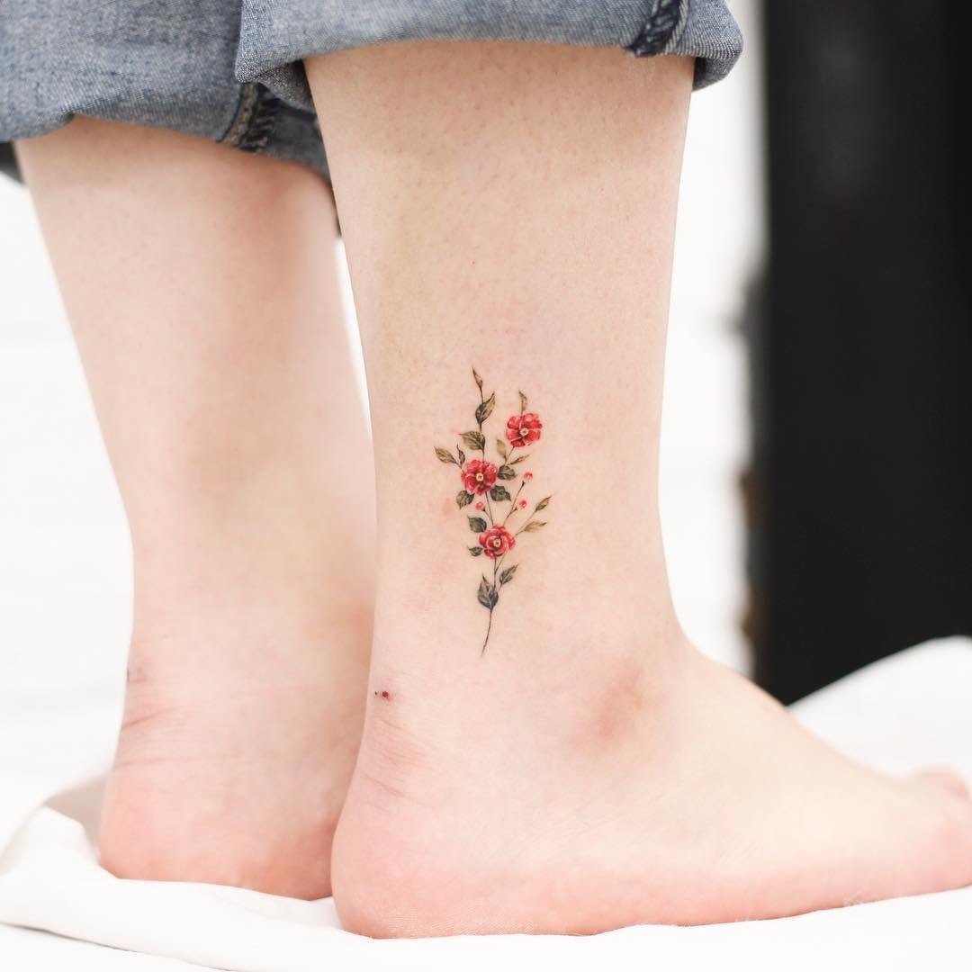 Charming ankle camellia tattoo with vibrant colors Tattoo Design