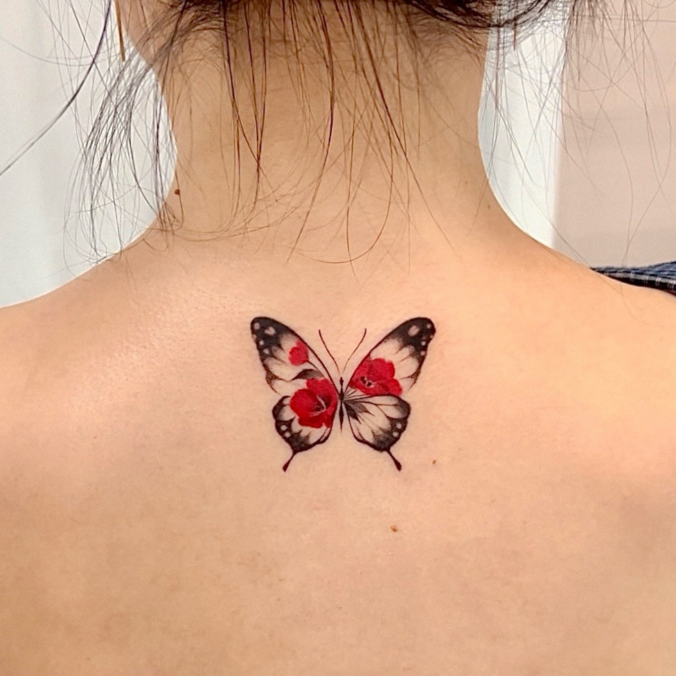 Elegant butterfly tattoo showcasing vibrant camellia flowers Tattoo Design