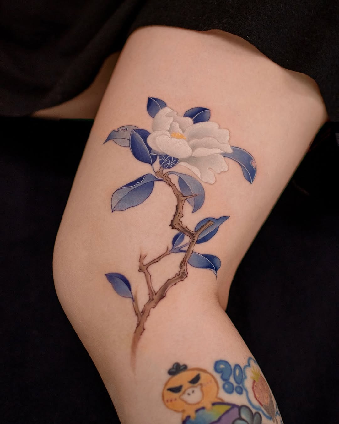 Elegant camellia tattoo with blue hues Tattoo Design
