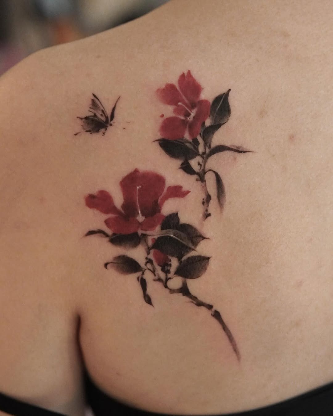 Elegant camellia tattoo with butterfly detail Tattoo Design