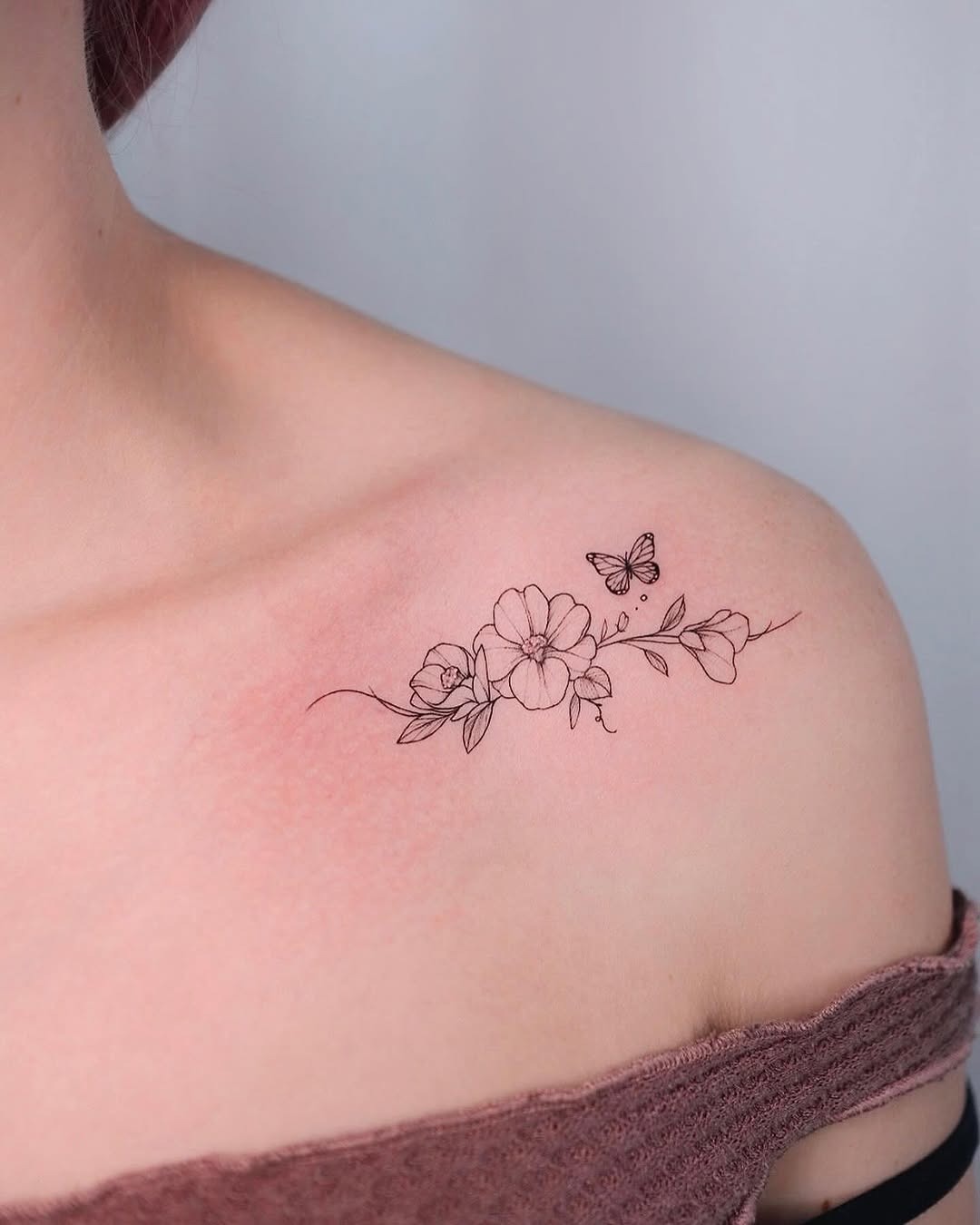 Elegant camellia tattoo with delicate butterfly detail Tattoo Design