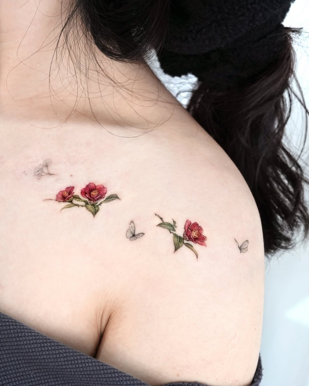 Elegant camellia tattoo with delicate butterfly details Tattoo Design