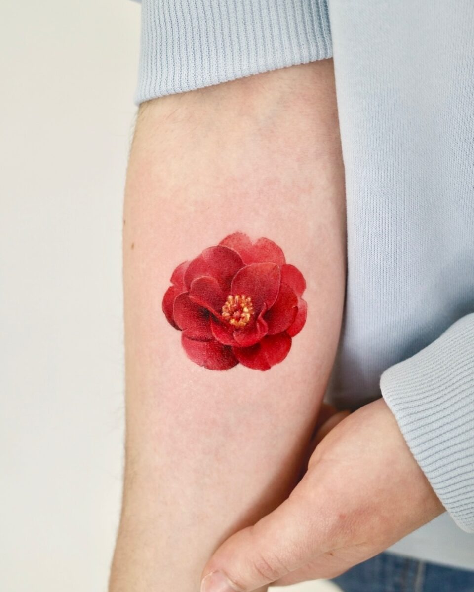 Stunning red camellia tattoo on forearm Tattoo Design