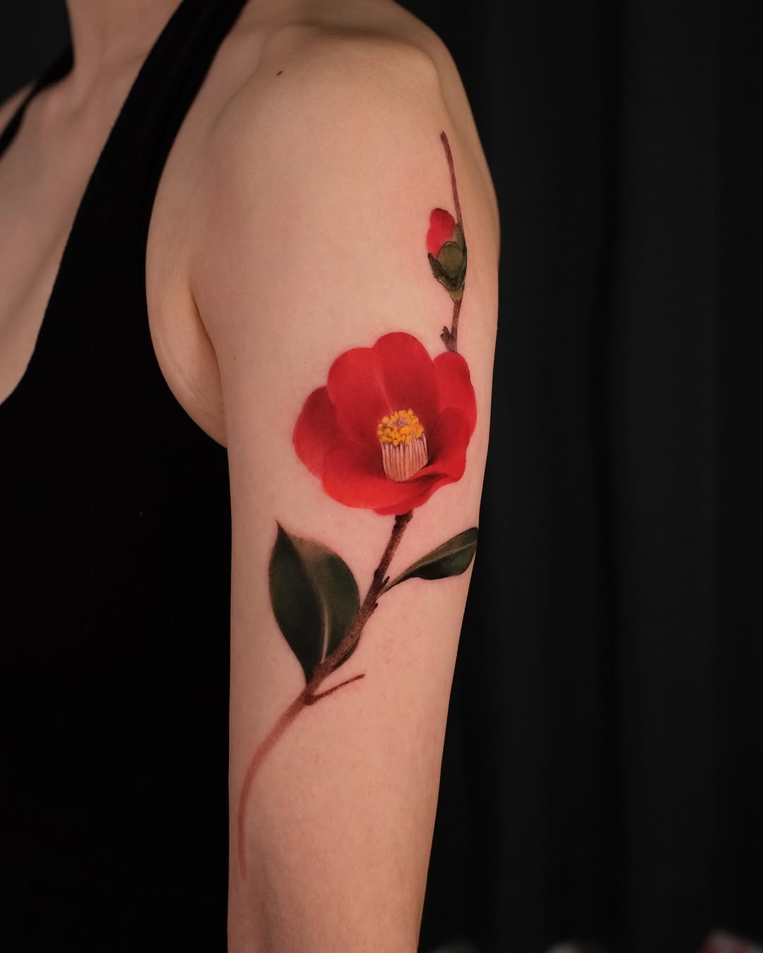 Vibrant red camellia tattoo on the arm Tattoo Design