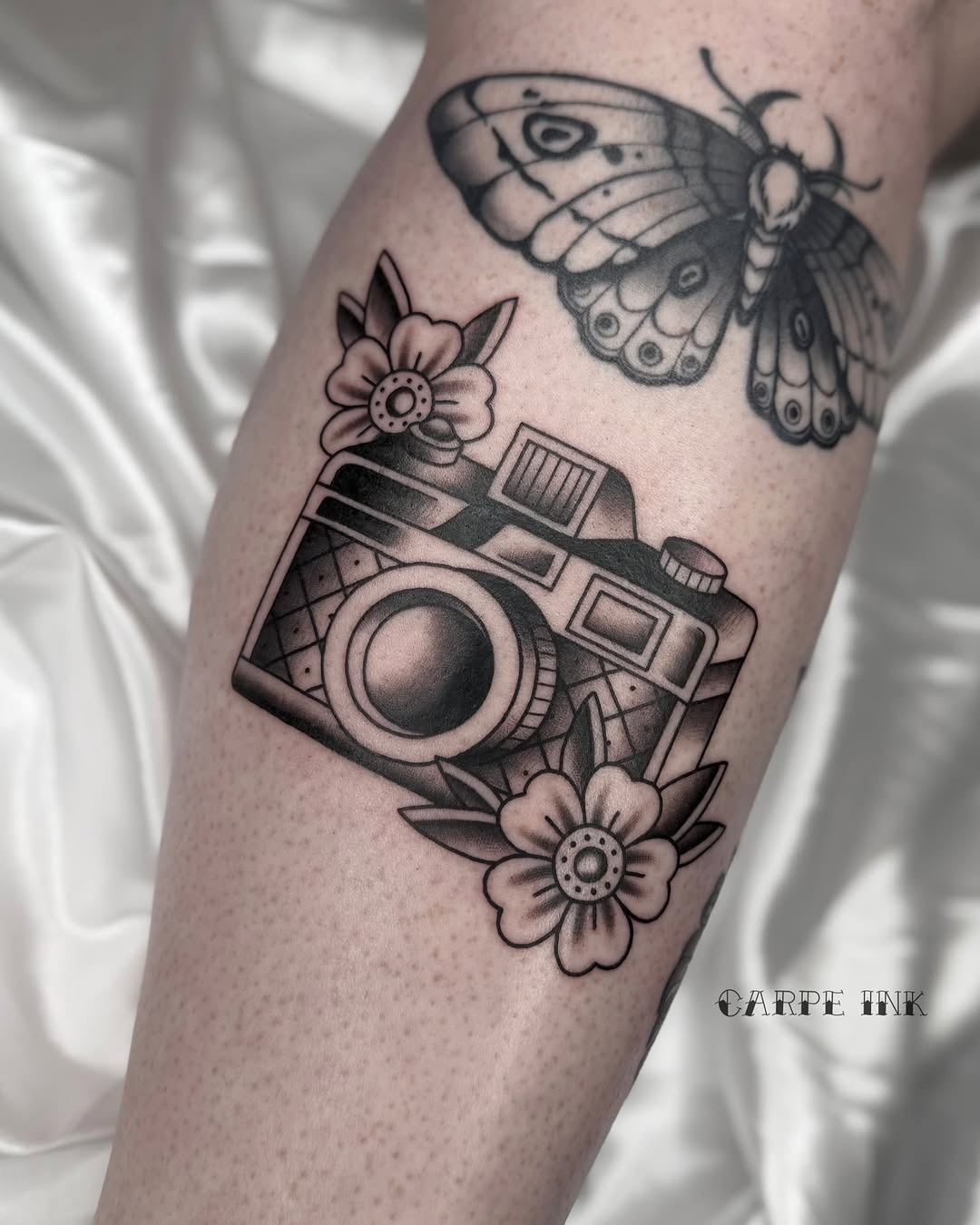Artistic camera tattoo surrounded by floral motifs Tattoo Design