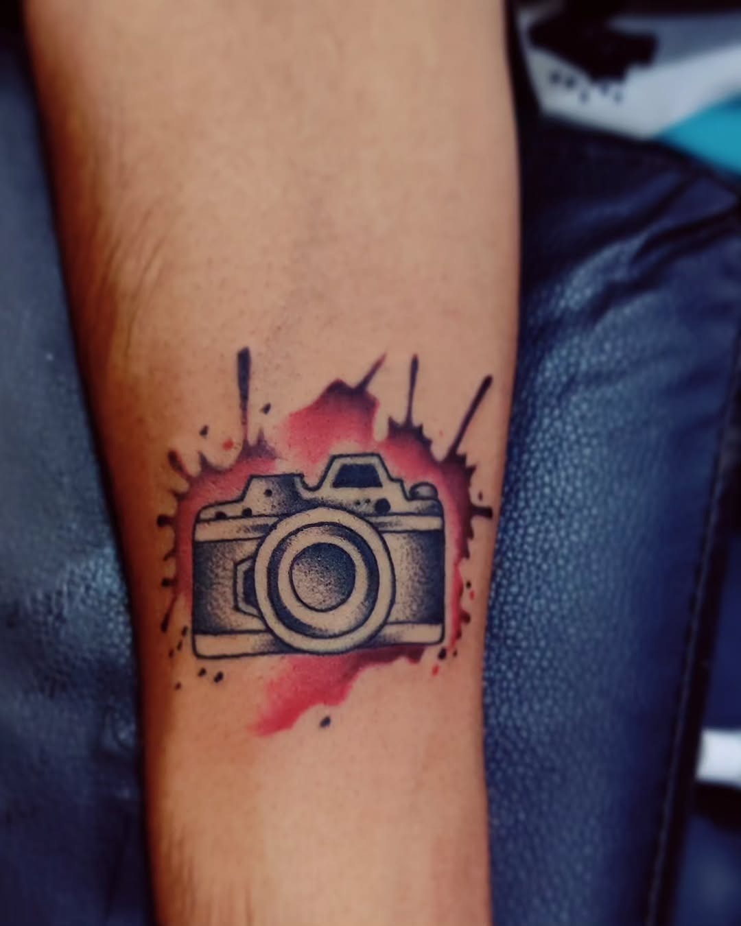 Artistic camera tattoo with vibrant ink splashes Tattoo Design