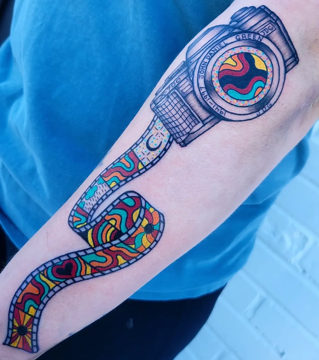 Vibrant camera tattoo with film strip design. Tattoo Design