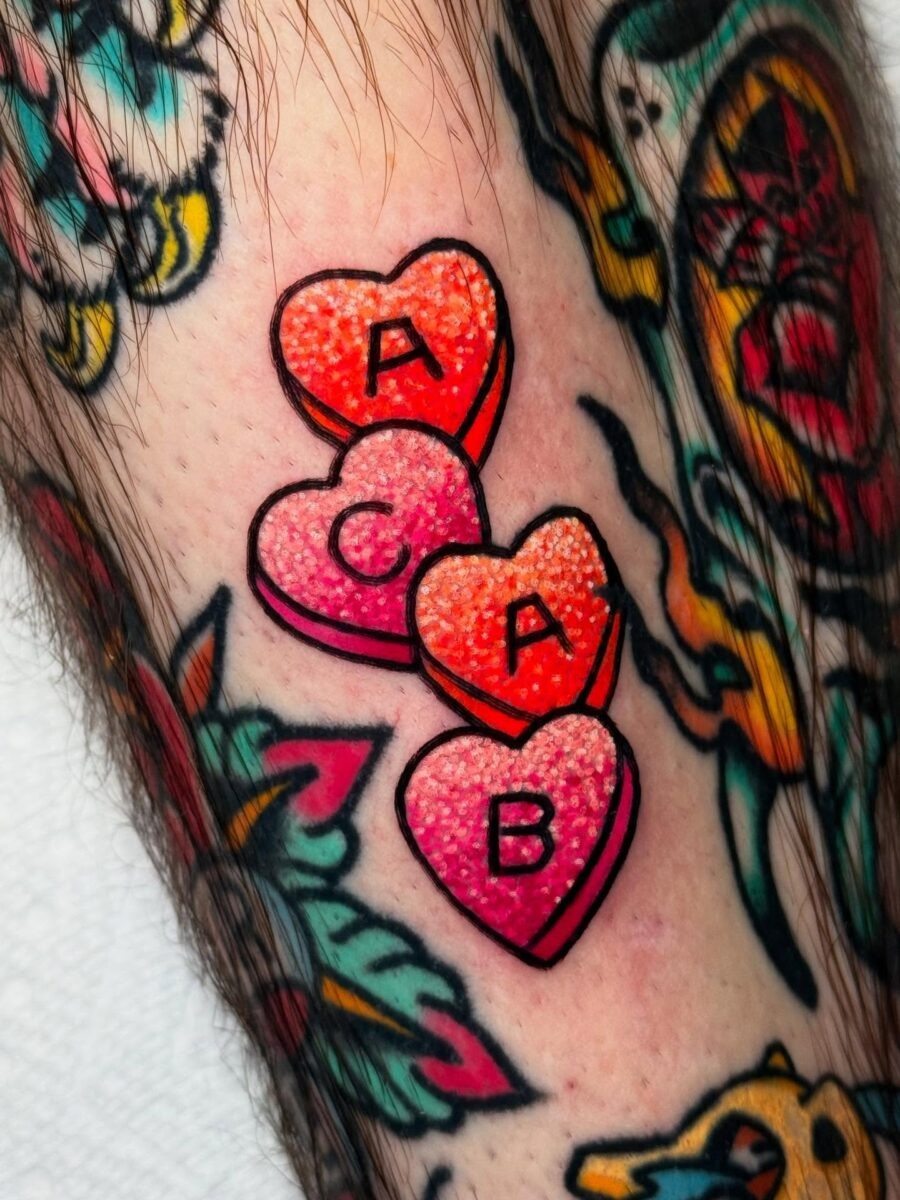 Colorful candy hearts tattoo with playful letters Tattoo Design