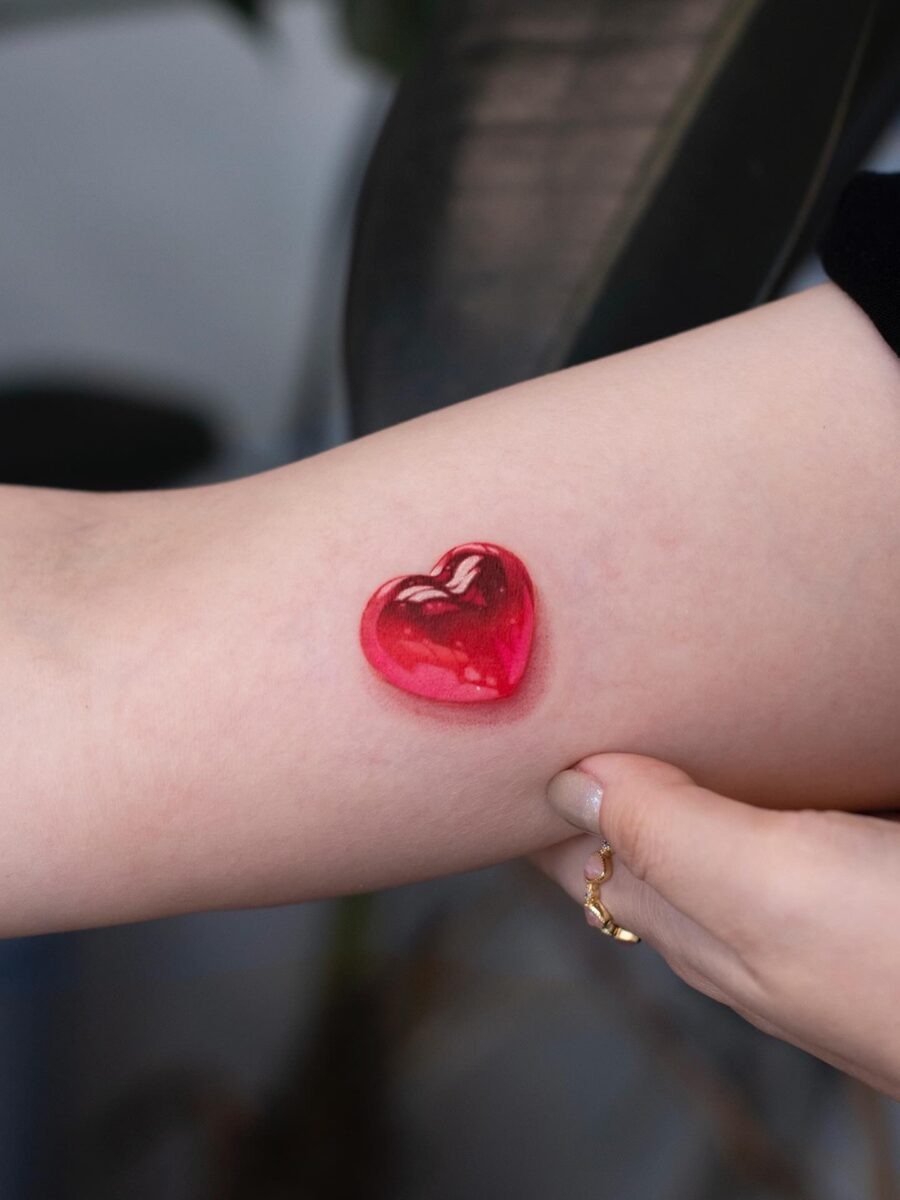 Glossy red heart tattoo on the arm Tattoo Design
