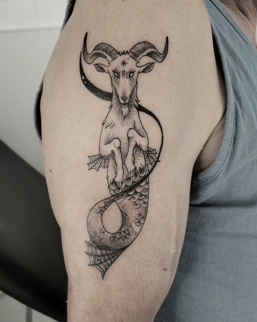 This striking Capricorn tattoo merges the classic goat imagery with a serpent tail, creating a unique and mythical vibe.
