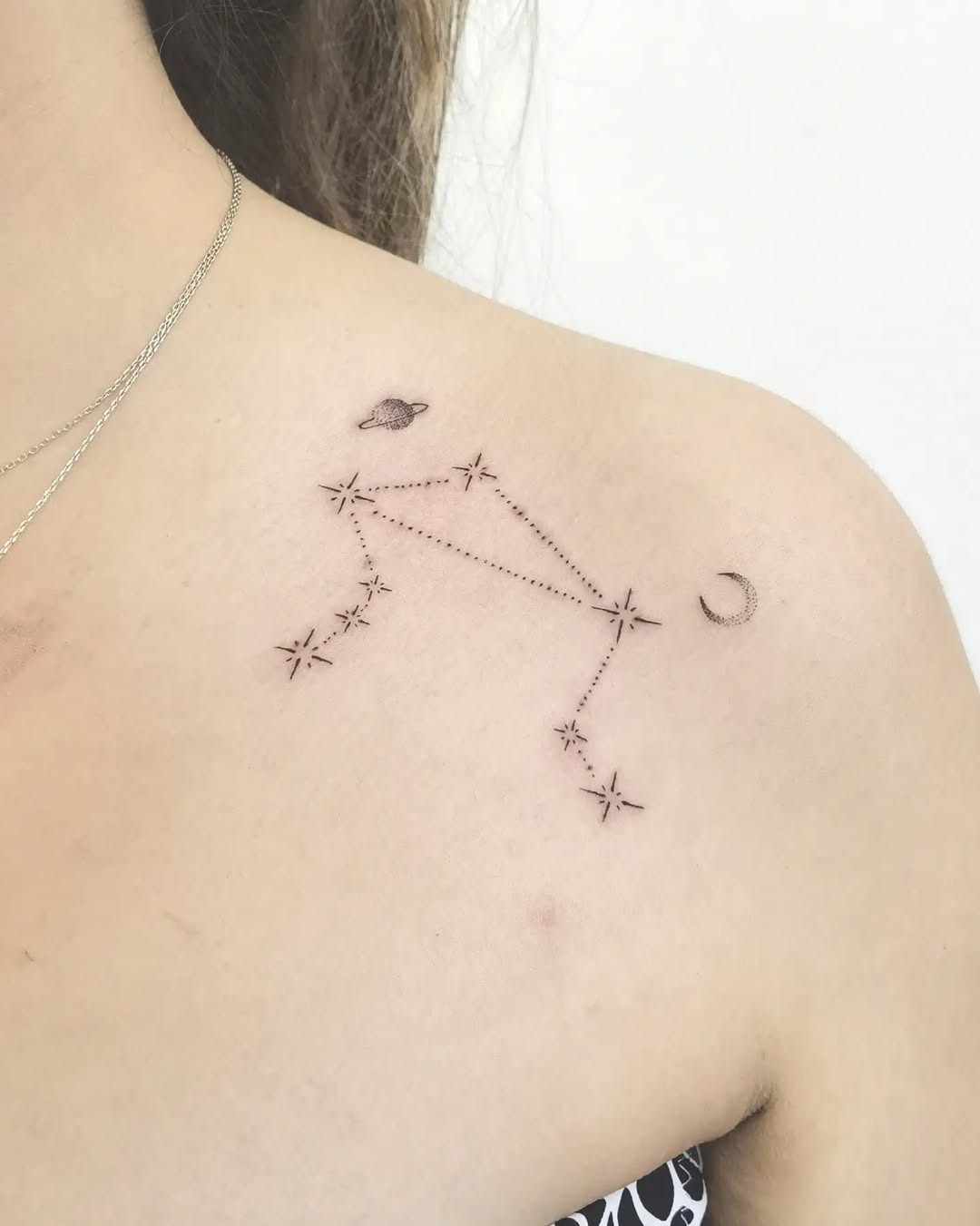 This tattoo beautifully incorporates the Capricorn constellation alongside a crescent moon and planet.