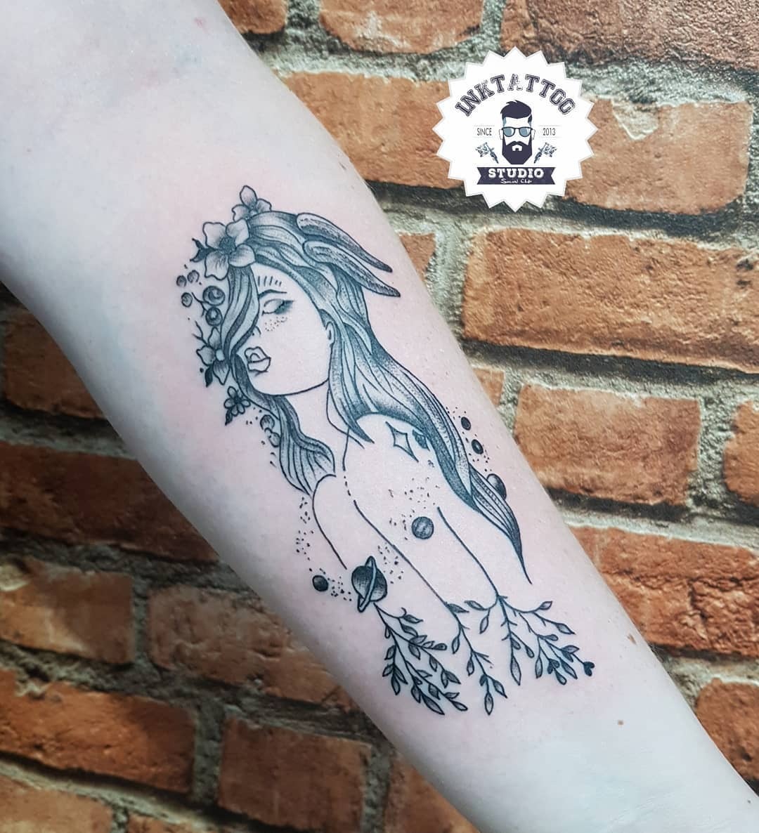 This Capricorn tattoo features a beautiful female figure intertwined with celestial elements.