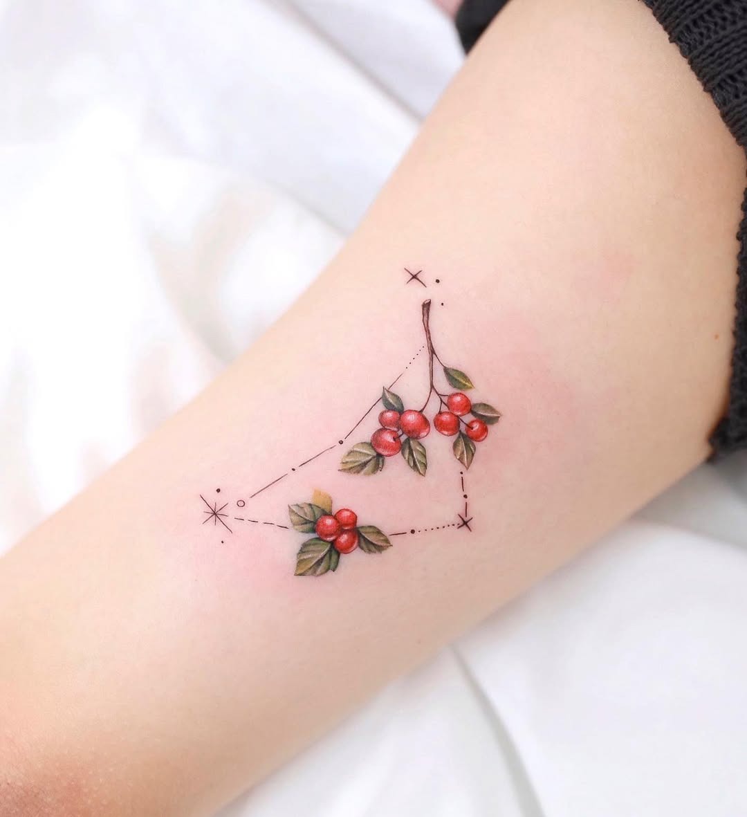This tattoo features a beautiful Capricorn constellation intertwined with cherry blossoms.