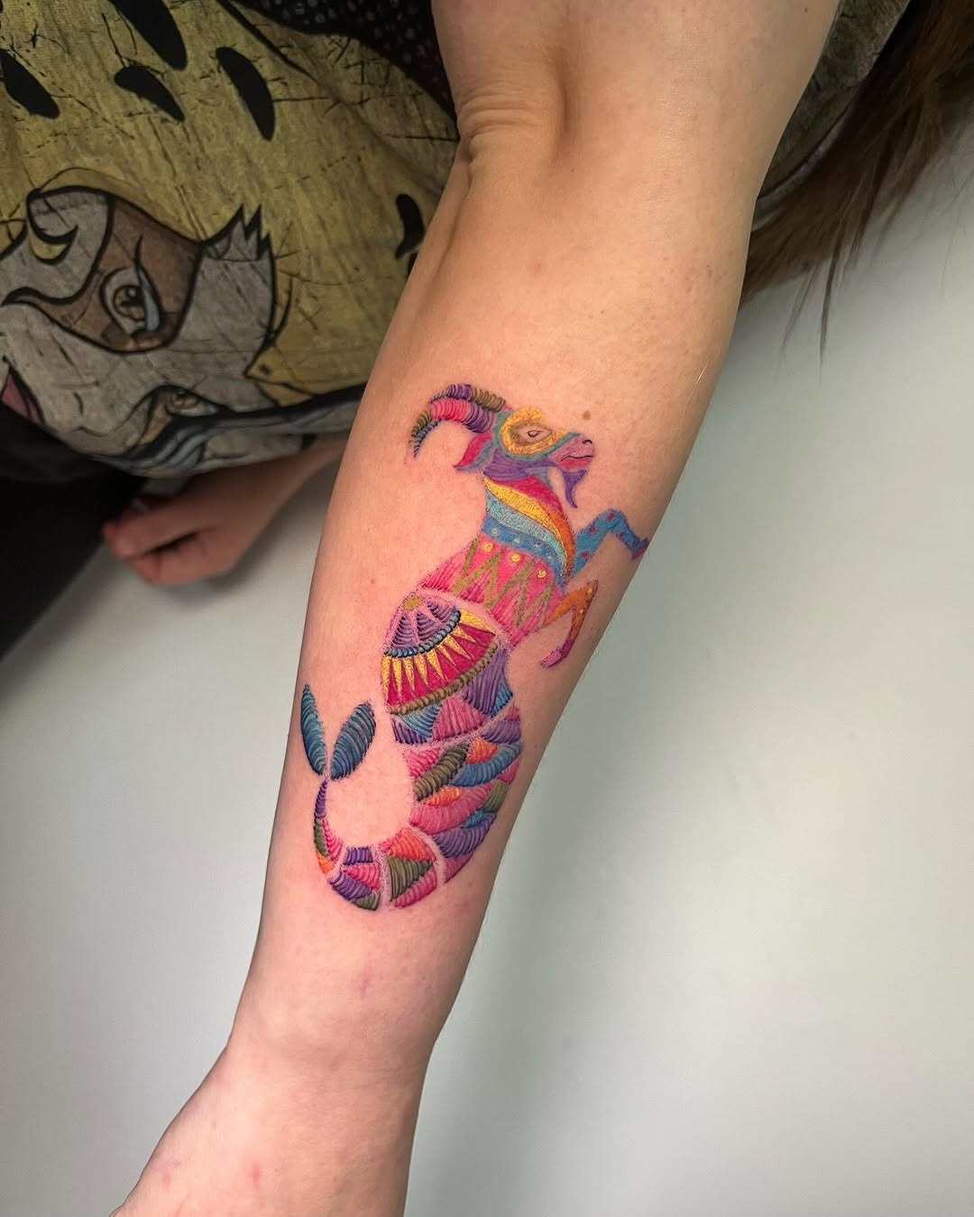 This Capricorn tattoo showcases an intricate design filled with eye-catching colors.