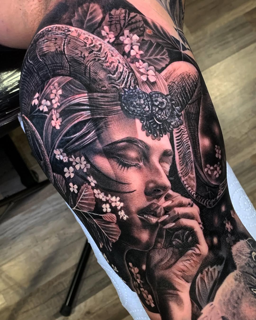 This stunning tattoo showcases a Capricorn goddess intertwined with blossoms and horns.