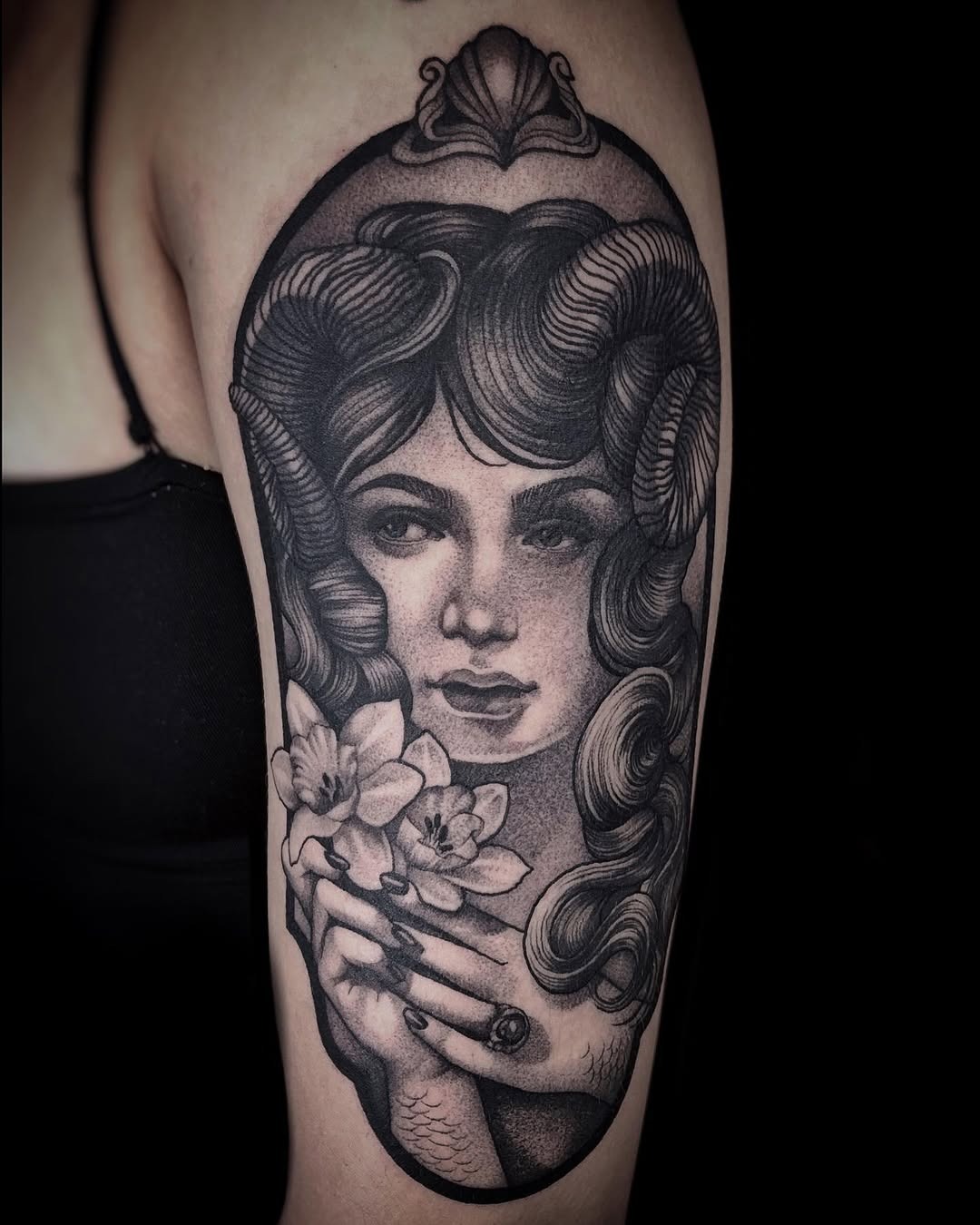This tattoo beautifully merges a serene goddess face with delicate floral elements.
