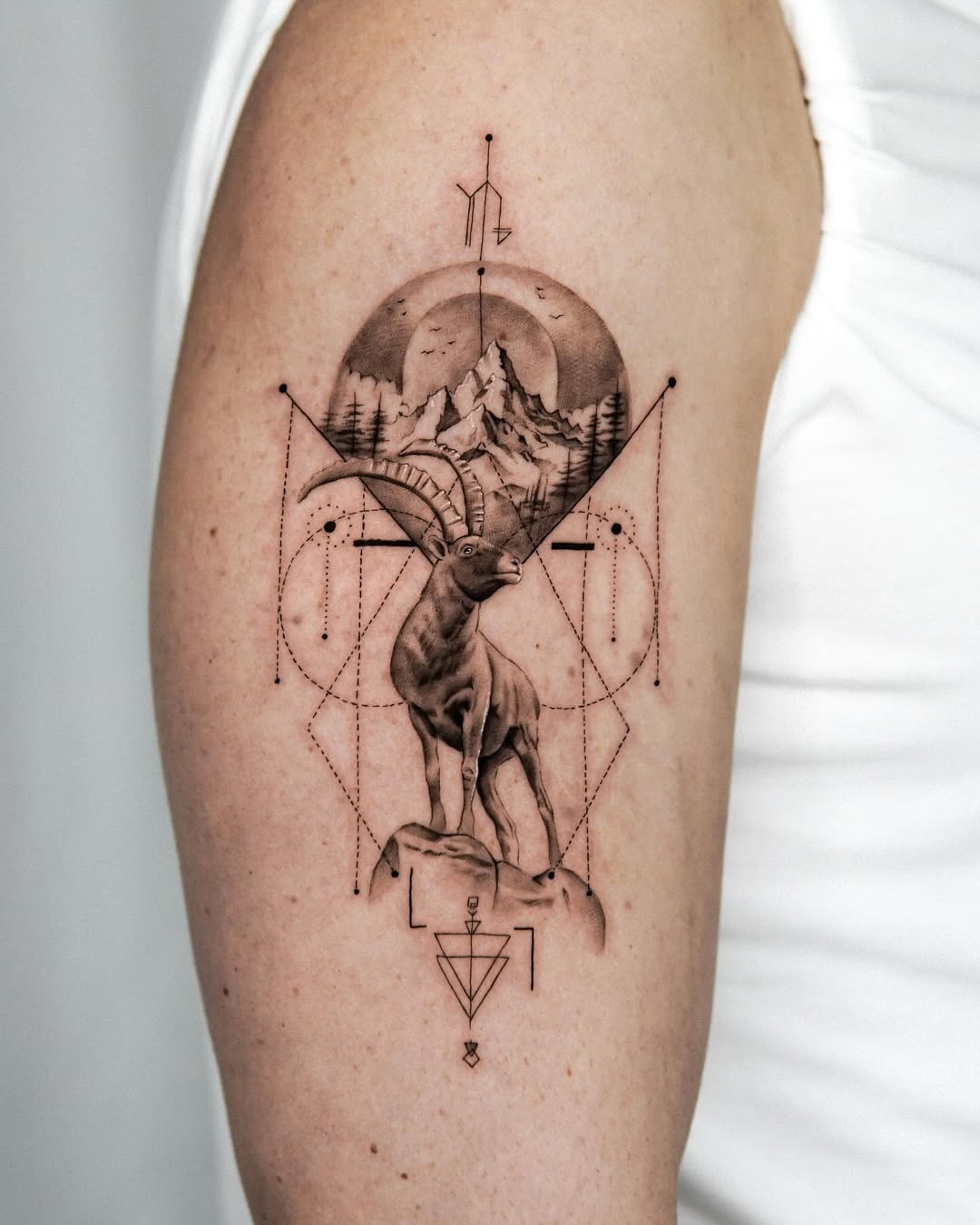 This Capricorn tattoo features a majestic mountain scene combined with geometric designs.