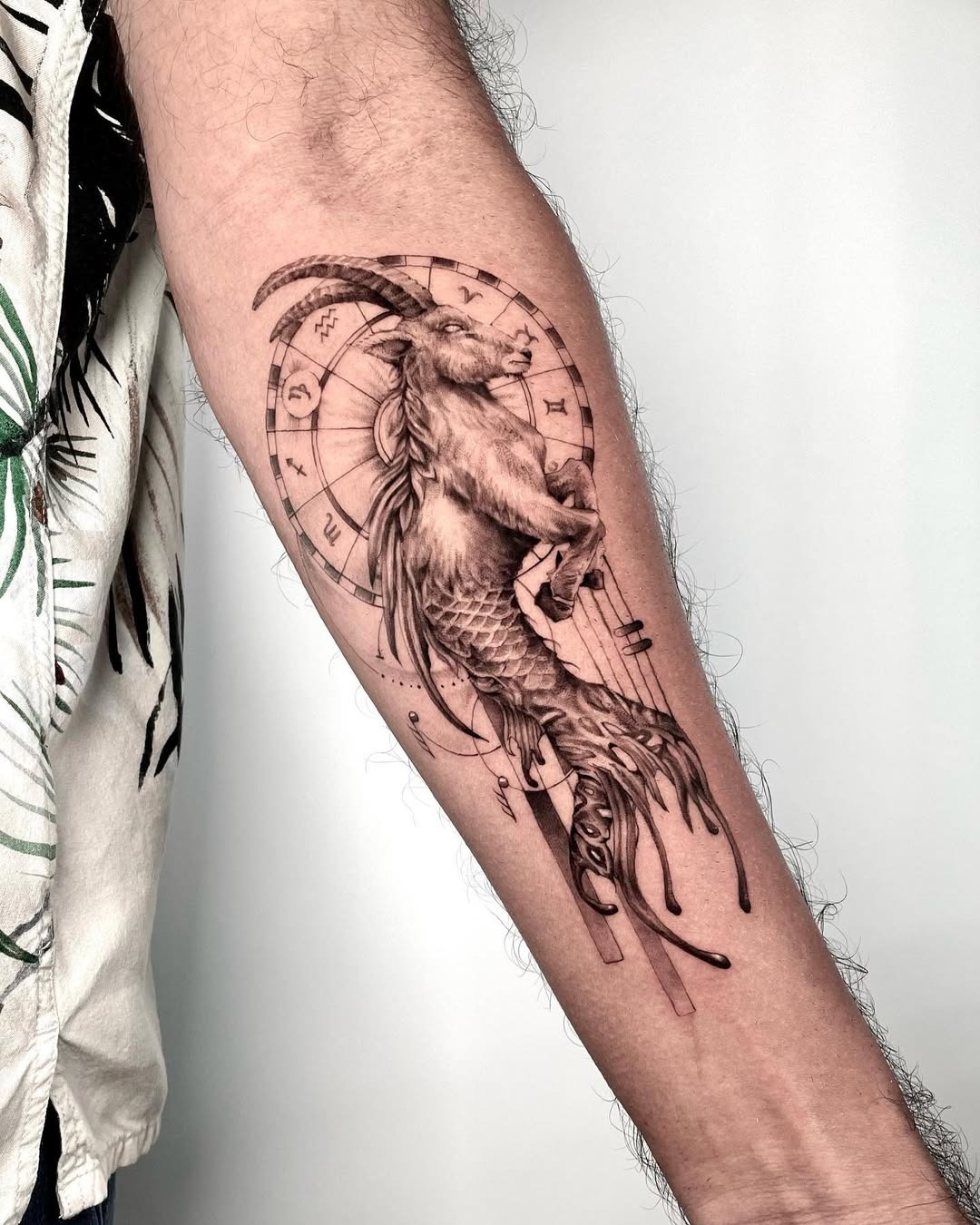 This tattoo beautifully merges the Capricorn symbol with a mermaid design.