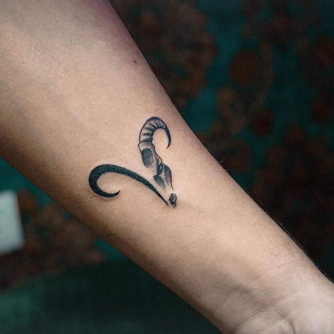 This Capricorn tattoo features a stylish ram design, elegantly curled and minimalist.