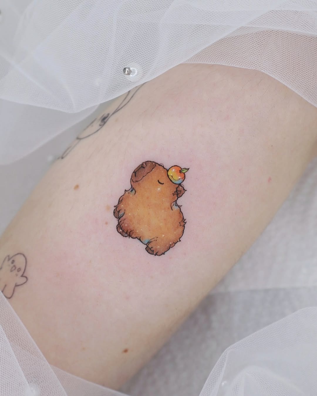 Adorable capybara tattoo enjoying a peach slice Tattoo Design