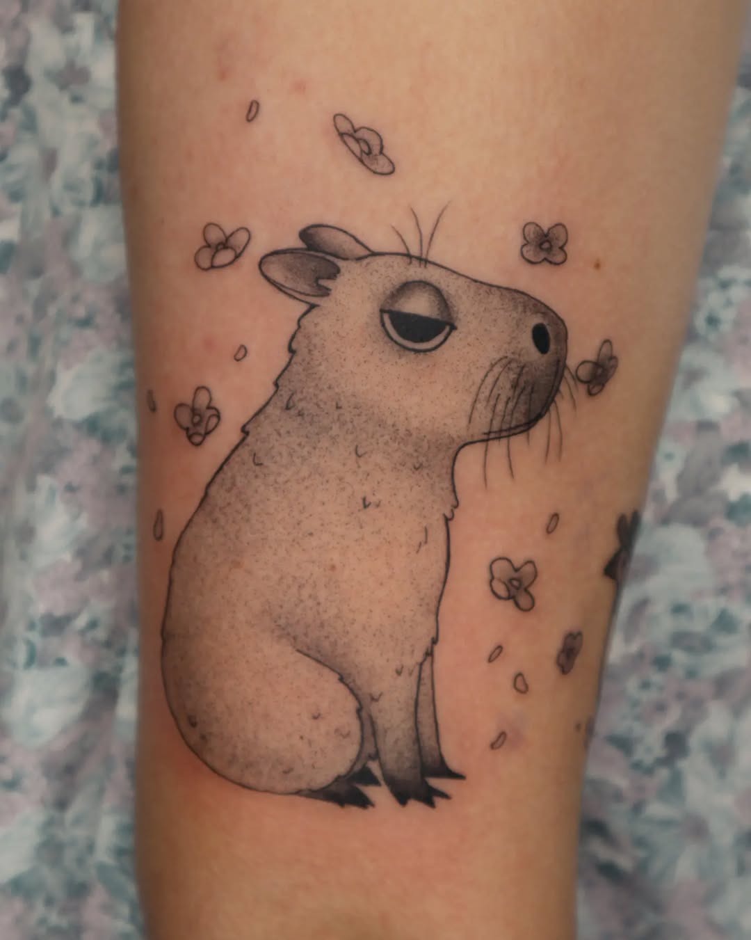 Adorable capybara tattoo with floral accents Tattoo Design