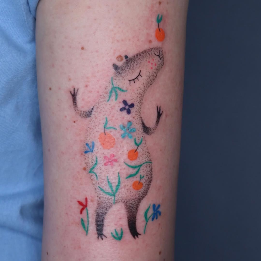 Vibrant Capybara Tattoo Surrounded by Nature Tattoo Design