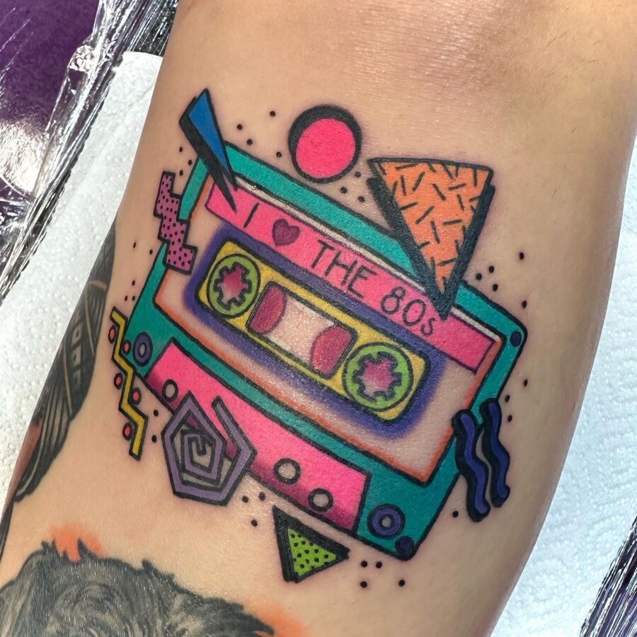 This tattoo captures the essence of the 80s with its playful colors and retro design.