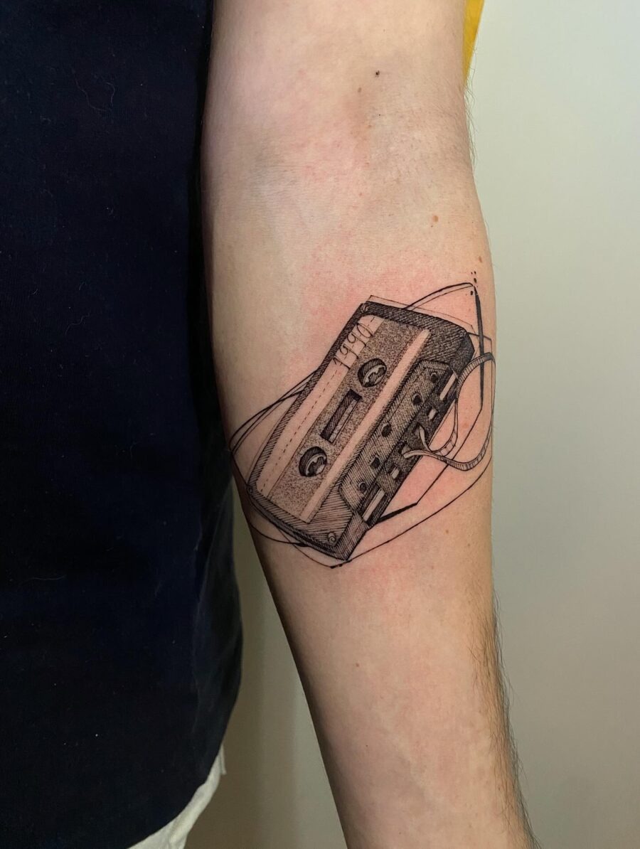 This tattoo features a detailed cassette tape design that exudes nostalgic vibes.