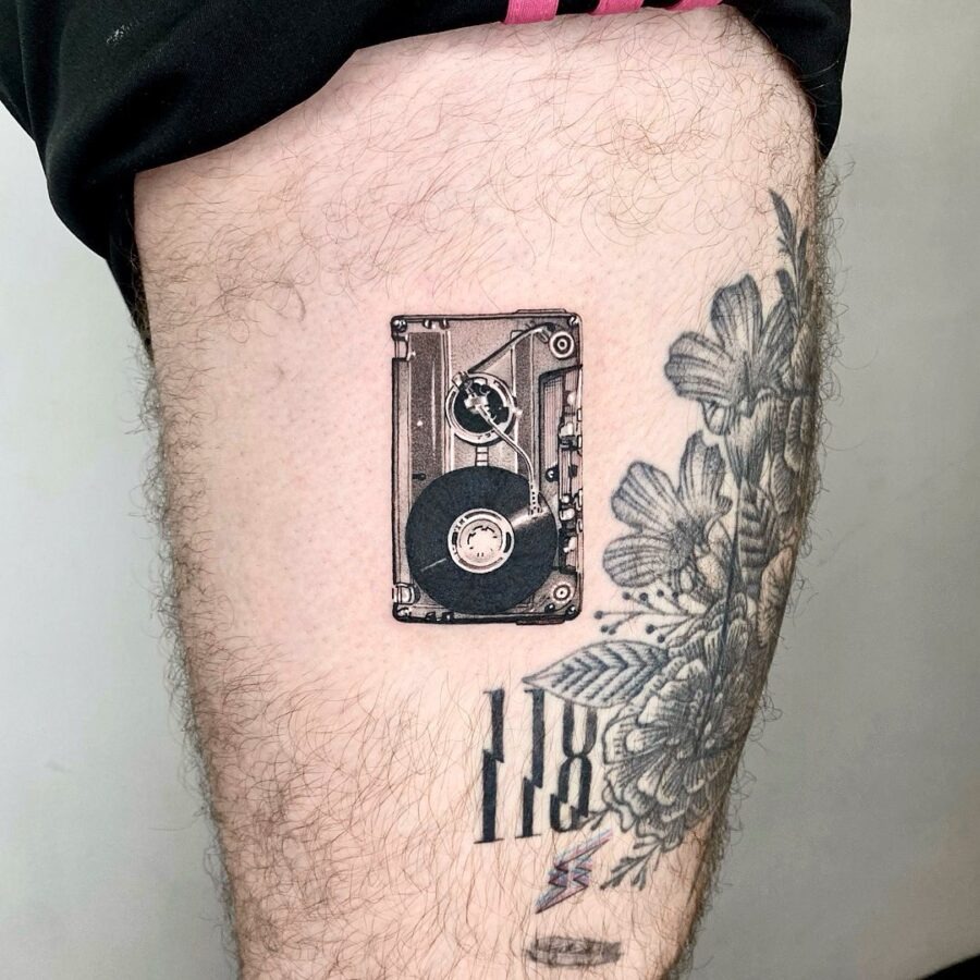 This tattoo showcases a detailed cassette tape, capturing the essence of vintage aesthetics.