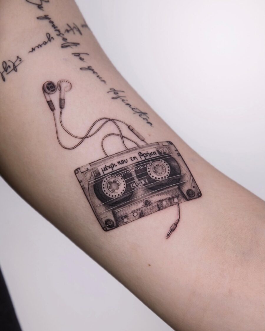This tattoo features a beautifully detailed cassette tape entwined with a pair of headphones.