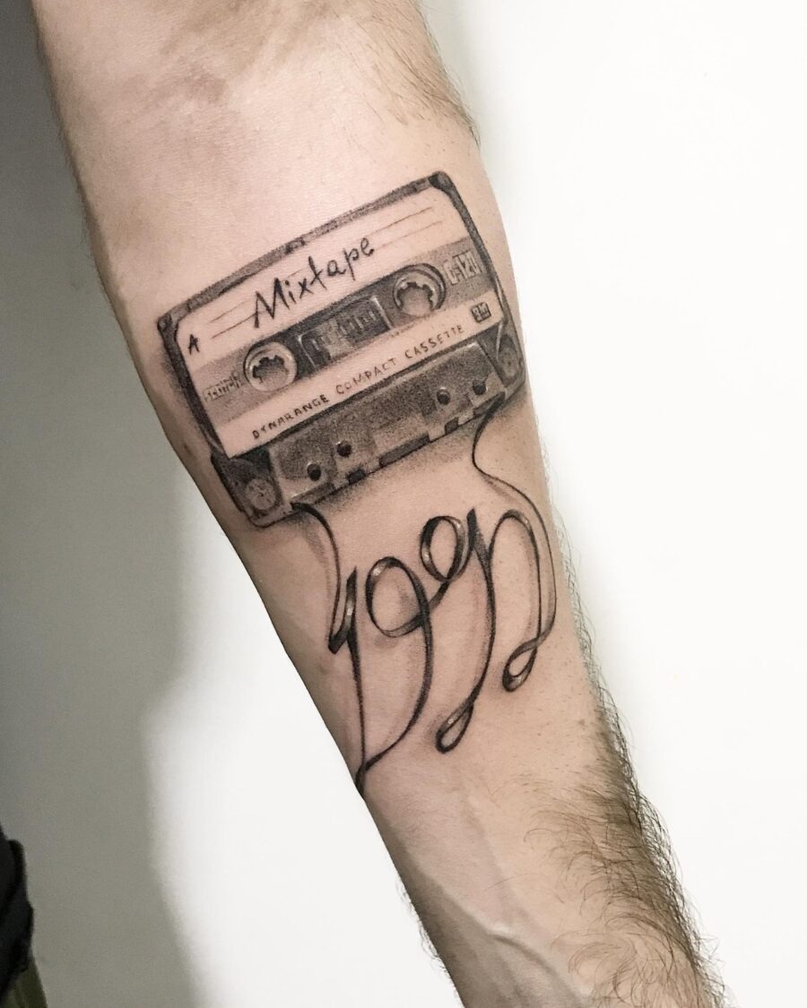 This tattoo features a detailed design of a cassette tape labeled 'Mixtape 1991.' The intricate shading and classic look evoke a sense of nostalgia for music lovers.