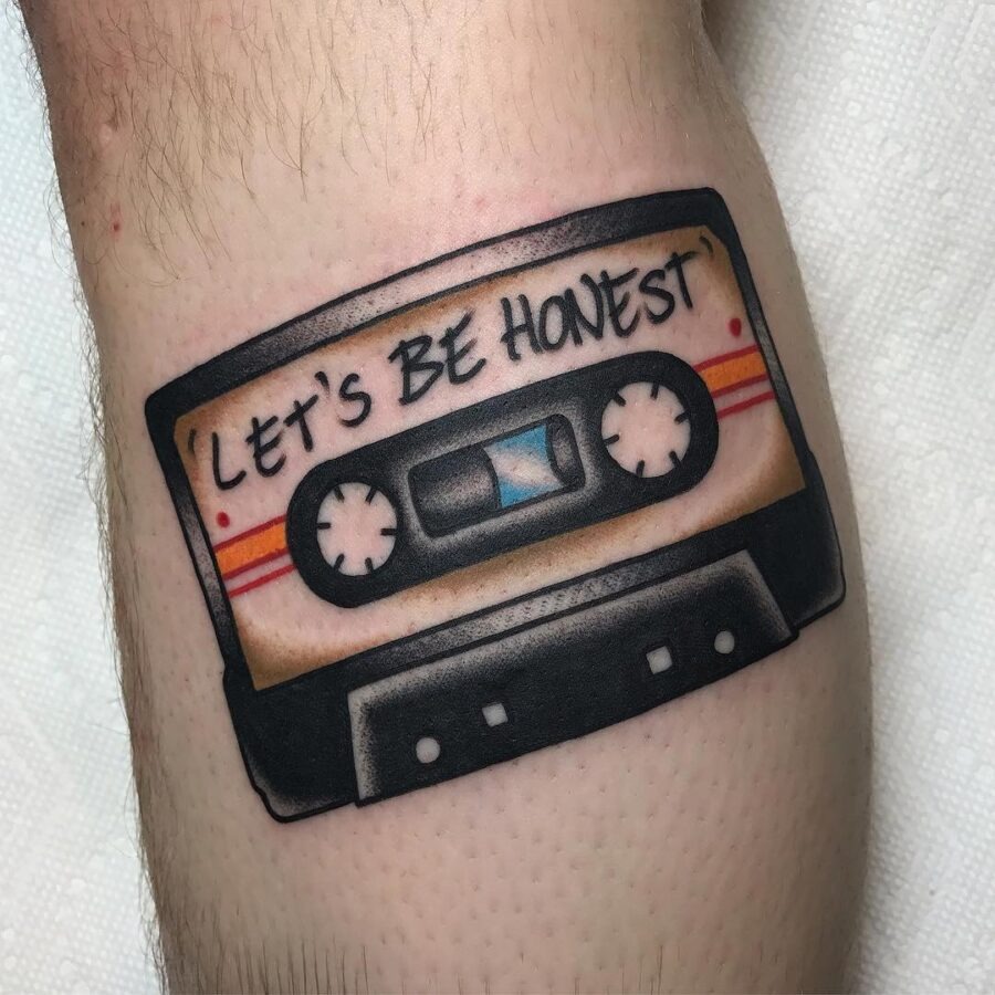This tattoo showcases a retro cassette tape, complete with iconic details like the reels and stripes.