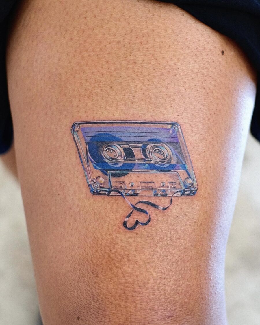 This tattoo showcases a vintage cassette tape design, detailed and.
